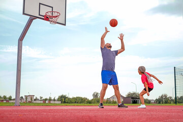 The father is trying to catch a basketball that the child threw with all his might. Dad and...