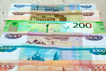 Banknotes of 5000, 1000, 500 and 200 rubles. Russian paper money of different denominations on a wooden old table. Fear of denomination and poverty. Wealth concept. World economic crisis and inflation - obrazy, fototapety, plakaty