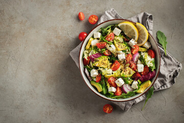 Delicious and healthy green salad of different leaves and vegetables with seeds and olive oil.