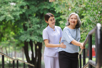 A nurse assisting an elderly patient in practicing walking by holding onto an iron railing is...