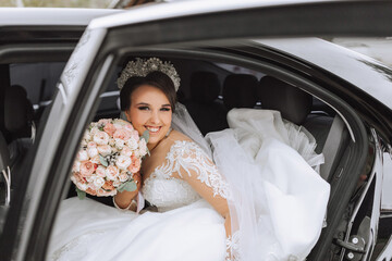 portrait of a happy and smiling bride in the car window looking at the camera