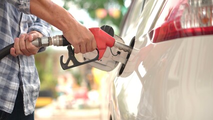 Closeup of man filling gasohol 91 gasoline fuel in car at gas station. Man Refueling Car At Gas...