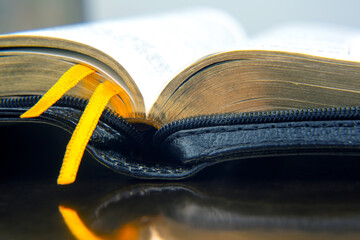 Yellow ribbon bookmark for a book. Open bible. The study of literature.