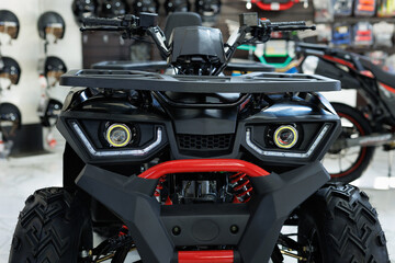 ATVs are sold in a motorcycle shop. Headlights close-up.