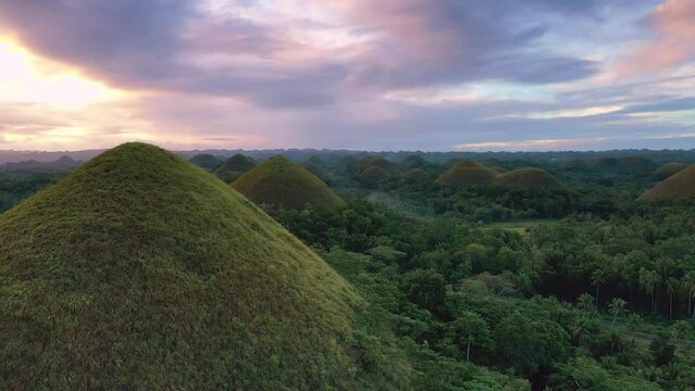Amazing aerial view of Chocolate Hills at sunset in Bohol, Philippines. Slow cinematic drone shot of famous landmark travel destination.