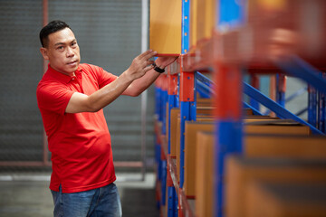 Fototapeta premium worker looking and pick up corrugated box in the warehouse storage