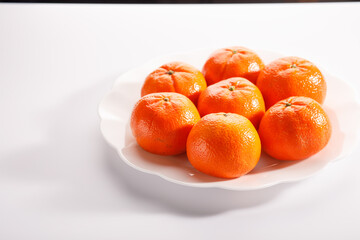 Fresh tangerine on a beige plate on white background. Colorful fruit background. Flat lay, top view, copy space