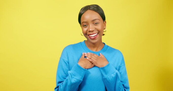 Beautiful woman puts hands on heart, infatuated and dreaming of crush, studio