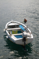 Small wooden boat with motor tied to a buoy in water in Montenegro, Europe