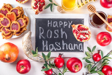 Rosh hashana jewish holiday background with red apples, honey, pomegranate, Shofar and goblet, jewish New Year holiday with traditional symbols. Happy Rosh hashana greeting card 