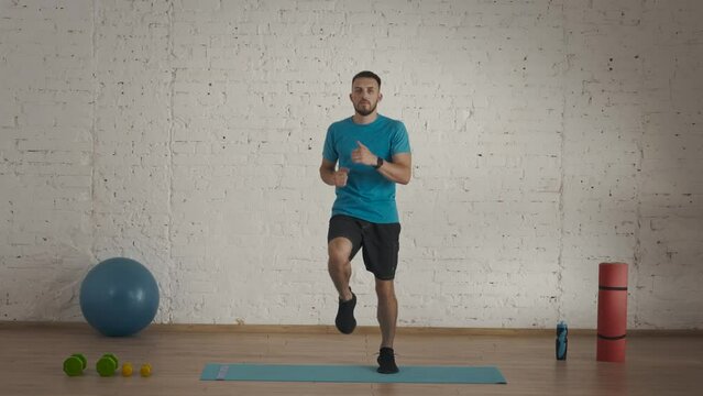 Man Fitness Coach In Sportswear Doing Running In Place Warm Up For Online Class At The Home Studio.