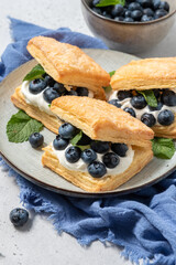 Stuffed puff cookies with whipped cream and blueberries