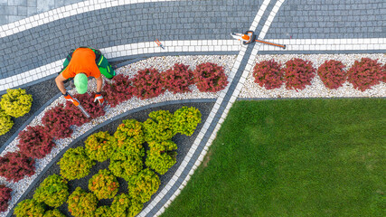 Aerial View of Garden Worker Pruning Small Driveway Area Plants