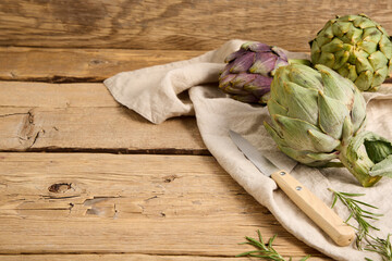 Green and purple artichokes on old wooden table