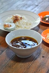 Rawon authentic from East Java, Indonesia. beef stewed in black gravy, served with salted duck egg, bean sprouts, crackers and chilli sauce. Indonesian traditional food and cuisine.