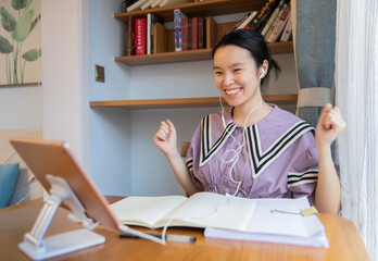 A young Chinese woman is learning on a tablet at home