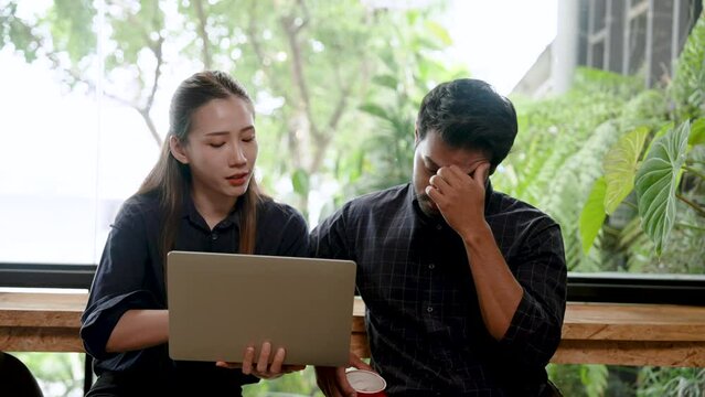 Asian couple, running cafe bakery together, sitting together discussing new business openings, men are tense when discussing income expenses profit margins, woman trying talk relieve boyfriend stress.