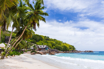 Anse Takamaka Beach view with palm trees and white sand