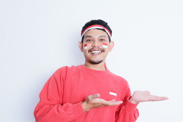 Happy excited face asian man showing something with his hand, isolated on white background for advertisement. celebrating Indonesia independence day.