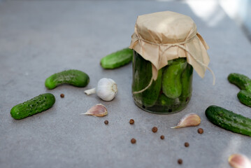 Pickled cucumbers in the jar. Ingredients for pickling cucumbers. Cucumbers, dill, garlic. Glass jars with pickles