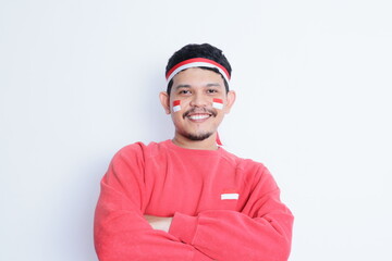 an indonesian man wearing a headband, crossing his arms while looking confidently at the camera....