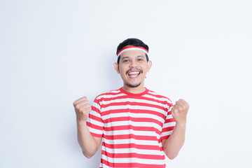 Naklejka premium Indonesian man clenched both fist showing excitement when celebrating independence day