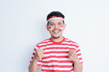 Naklejka premium Indonesian man clenched both fist showing excitement when celebrating independence day