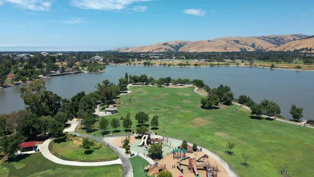 drone fly over of lake Elizabeth lake in Fremont california with a green landscape and blue sky