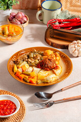 Lontong sayur or vegetable rice cake is an Indonesian traditional rice dish made of pieces of lontong served in coconut milk soup with shredded chayote, tempeh, tofu, hard-boiled egg, sambal, rendang