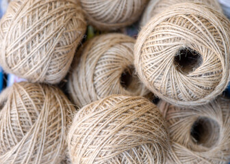 rolls of natural hemp wire for parcel twine, string, packing or diy.fencing strand,polypropylene orange, blue twine.spools in plastic bag,woman hand,market store sale concept