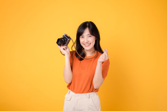 Young woman with a joyful smile, holding a camera for her exciting holiday journey.