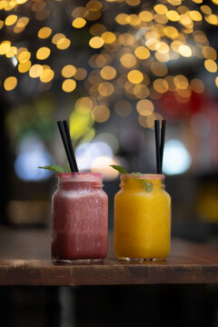 a couple of fruit smothiewith lights at the bokeh background 