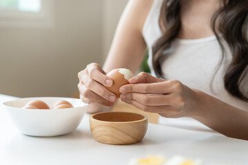 Obraz na płótnie Canvas woman holding boil egg and pilling off eggshell