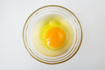 Raw egg, top view of one raw egg in a glass bowl