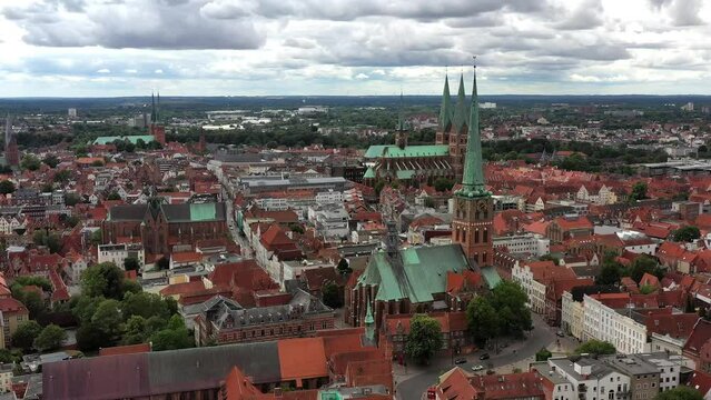 Drone shot, drone video, drone flight, aerial view, flight over the historic city centre of Luebeck with a view of the Gothic St. Jacobi Church, behind it the St. Marien Church and the Cathedral