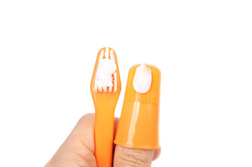 Dog toothbrush with toothpaste set held by hand. Soft finger brush and toothbrush comparison. Used...