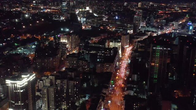 Aerial flying drone view of night Kiev city center. Night city Kyiv. Modern area in the center of Kiev. City lights. Aerial View of European City at Night with Illuminated Light from Cars