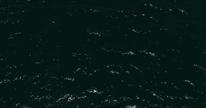 A drone flies over the dark waves of the sea