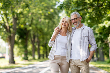 Fototapeta premium Portrait Of Beautiful Elderly Couple Walking Together In Summer Park