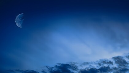 Dark blue abstract background. Night sky with clouds and moonlight. Navy blue sky background with copy space for design.