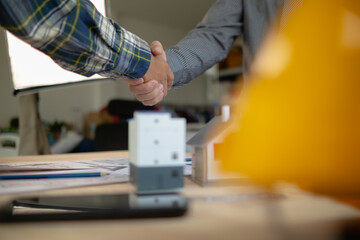 construction engineer joins hands with architect to congratulate housing project that architect team has designed and has been accepted by engineering team. concept of handshake for congratulations