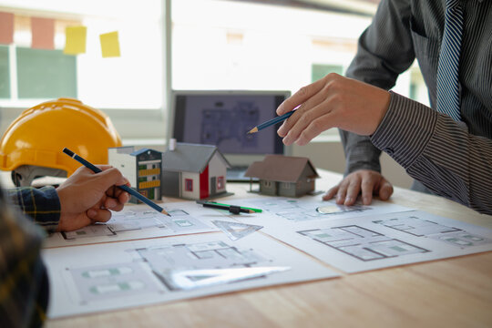 Construction engineers discuss and exchange ideas with architects to improve house plans to meet customer needs. A concept for exchange of design ideas between construction engineers and architects.