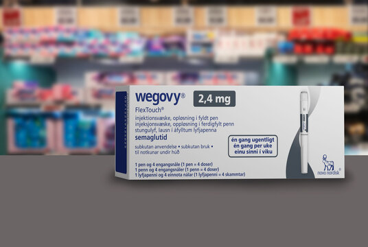 Packaging box of Wegovy (semaglutide) injectable prescription medication, weight-loss drug from Novo Nordisk A/S.  Blurred shop shelves in background. Copenhagen, Denmark - August 22, 2023.