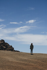 Woman standing up on volcanic area with lunar landscape 
