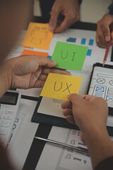 Close up ux developer and ui designer brainstorming about mobile app interface wireframe design on...