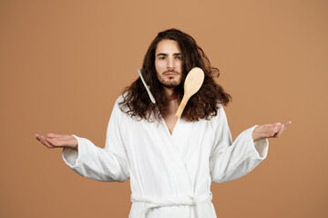 Unhappy Man Having Problem With Long Hair Detangling, Beige Background