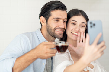 Happy couple drinking coffee at kitchen counter in the morning at home