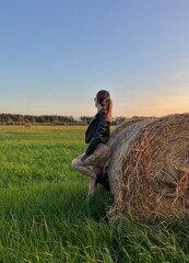 Naklejka na ściany i meble person with hay bale in field