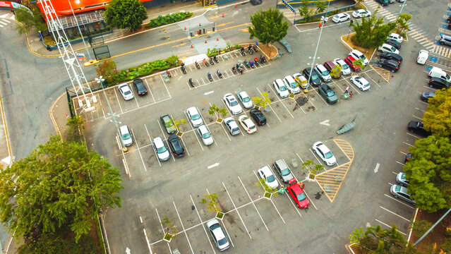 Estacionamento de ve&iacute;culos em um supermercado visto do alto. 