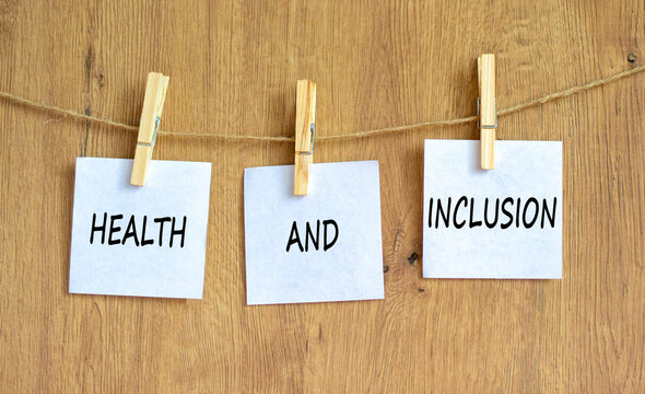 Health and inclusion symbol. Concept words Health and inclusion on beautiful white paper on clothespin. Beautiful wooden background. Business motivational health and inclusion concept. Copy space.